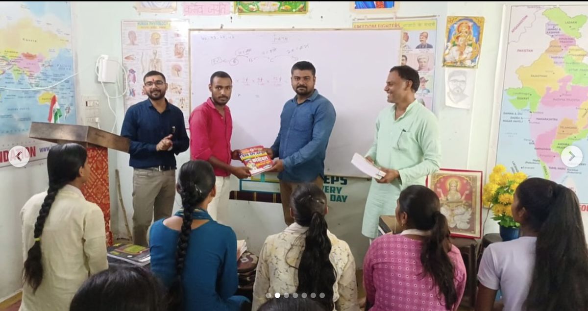 Jana Vidya Foundation volunteers distributing books to students in a classroom in Prayagraj